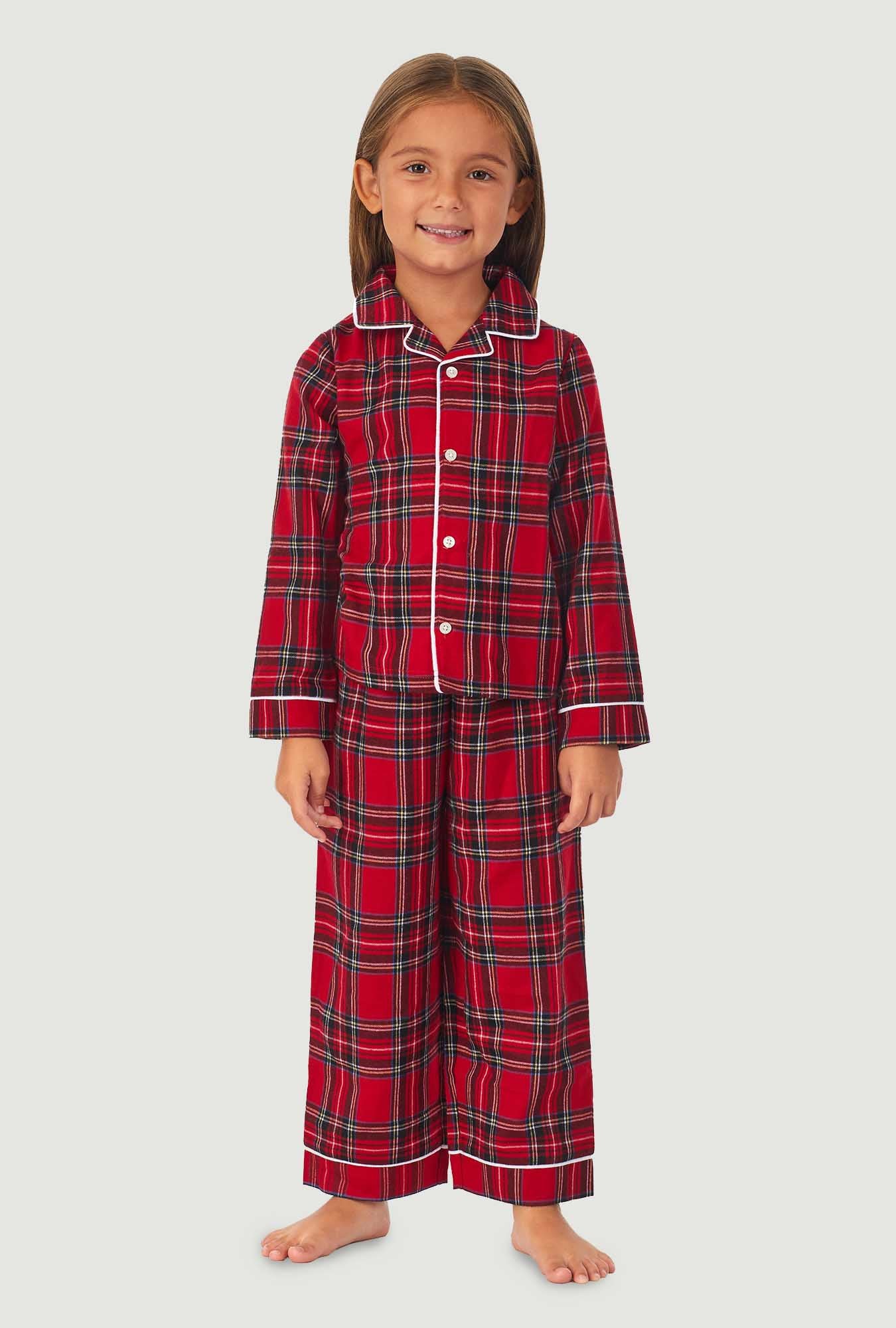 A girl wearing a red tartan long sleeve pajama set.