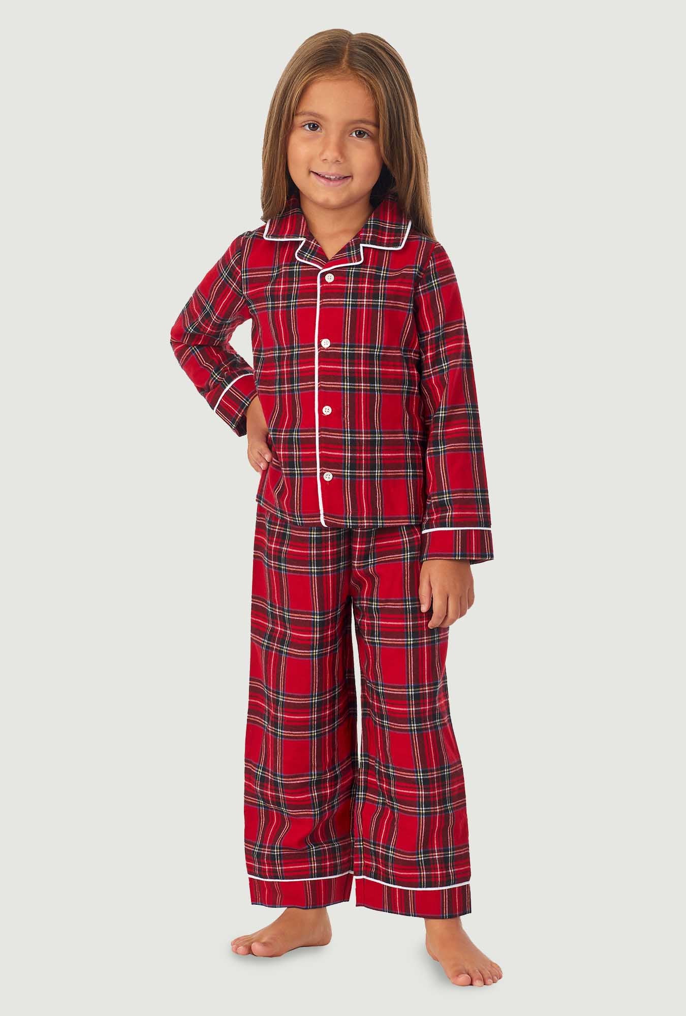 A girl wearing a red tartan long sleeve pajama set.