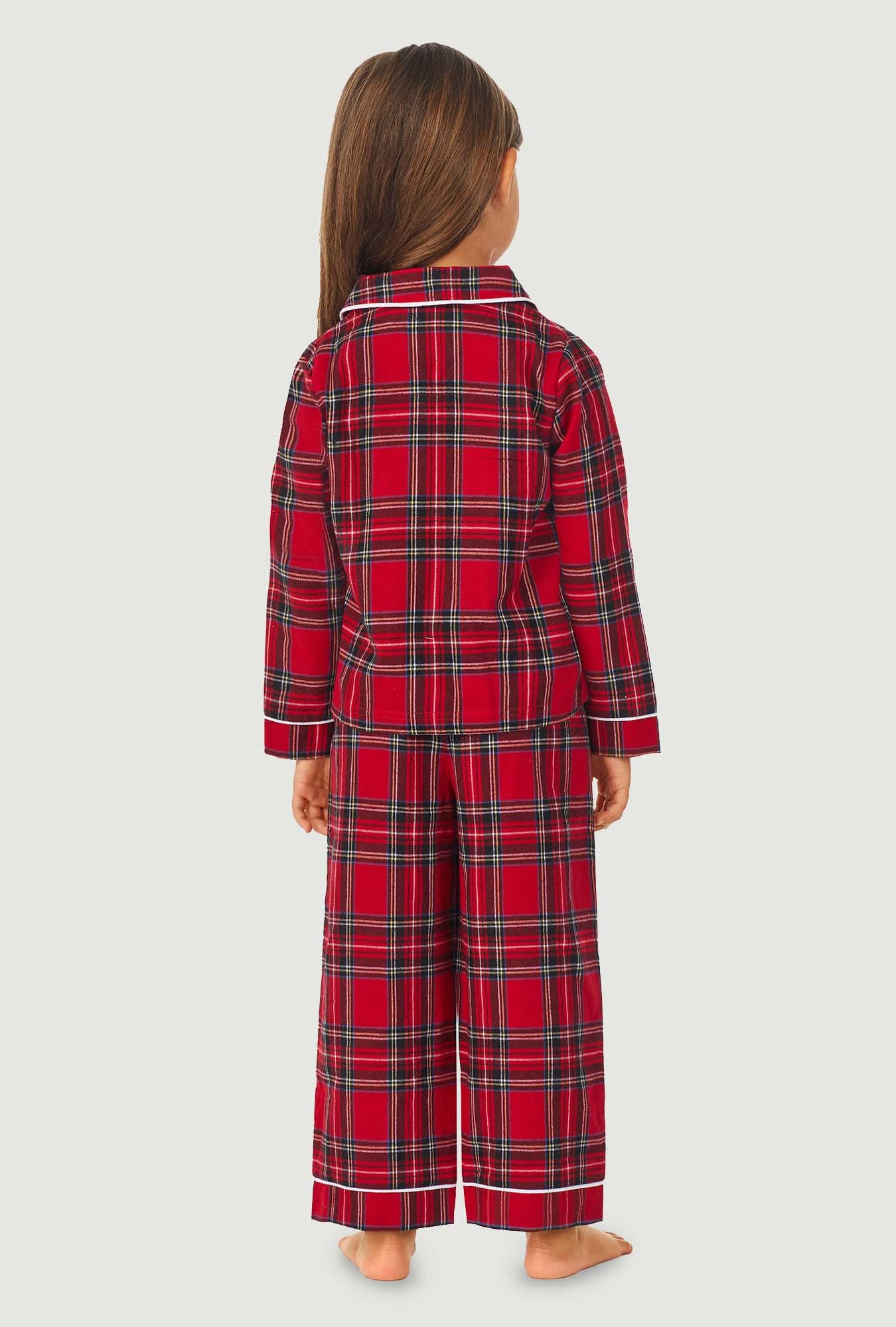 A girl wearing a red tartan long sleeve pajama set.