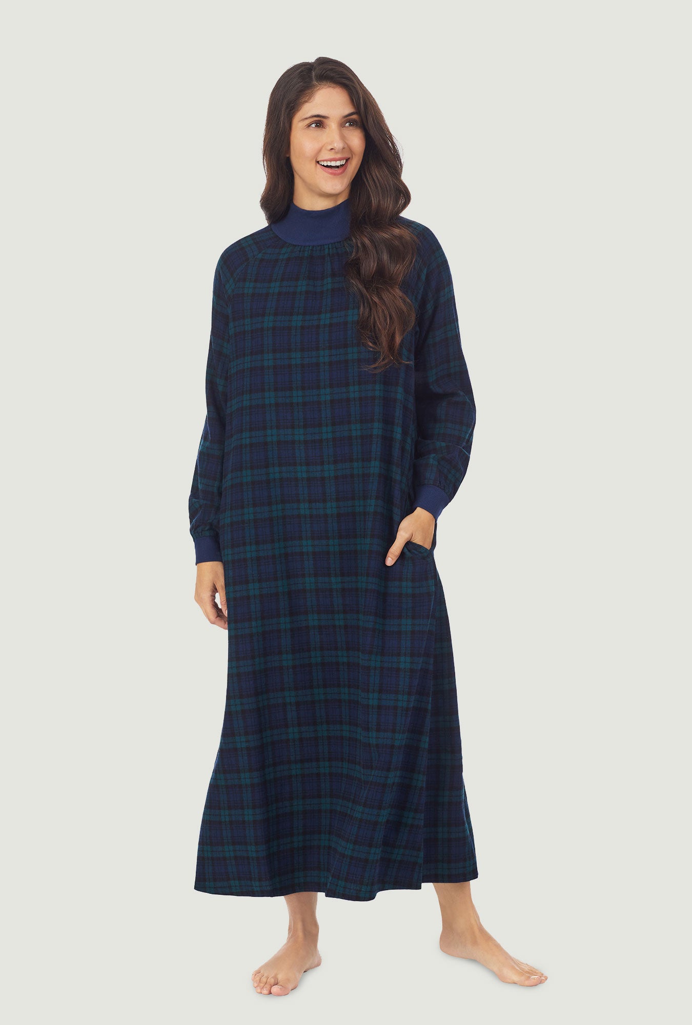 A lady wearing a black watch plaid long sleeve flannel pop over gown.