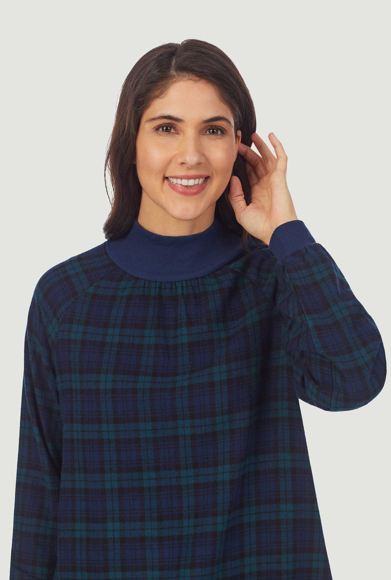 A lady wearing a black watch plaid long sleeve flannel pop over gown.