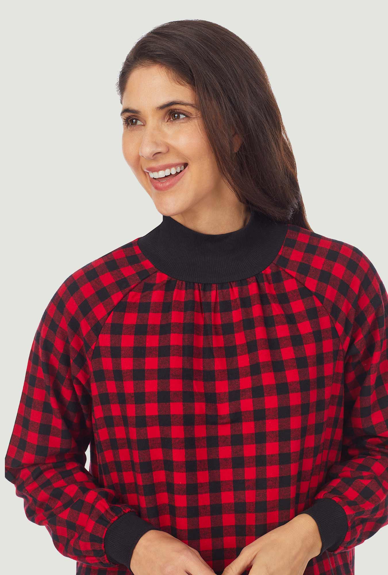 A lady wearing a red buffalo check long sleeve pop over flannel gown.