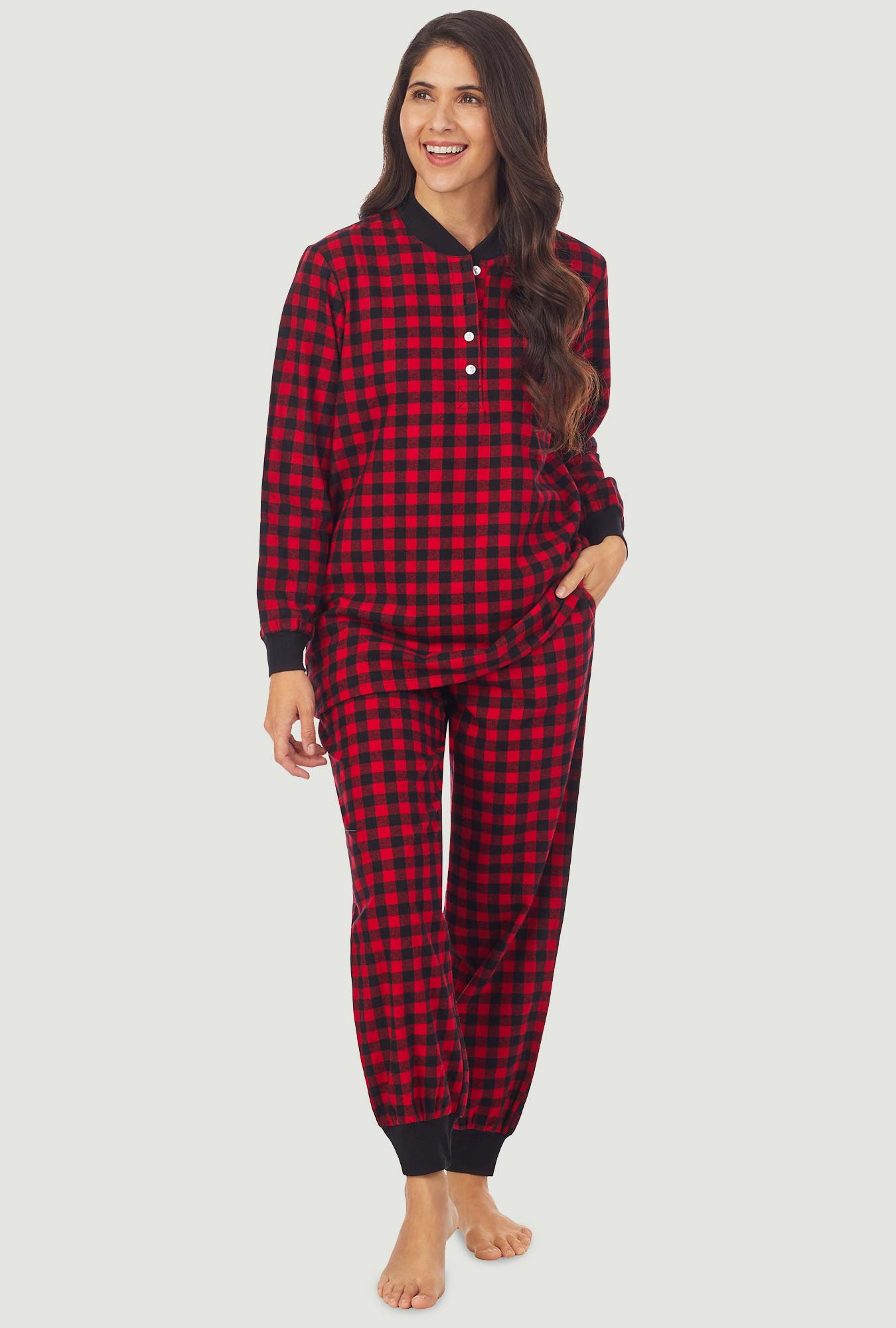 A lady wearing a red buffalo check long sleeve ski pajama.