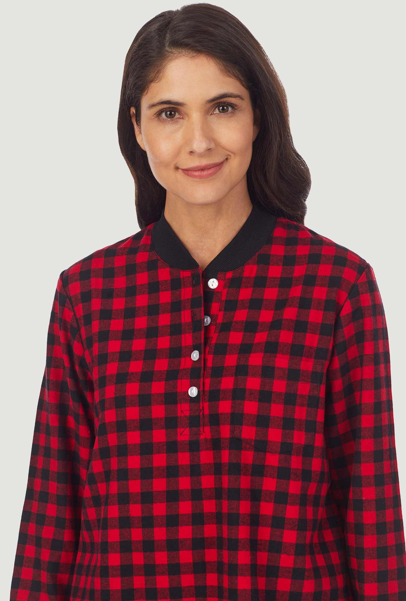 A lady wearing a red buffalo check long sleeve ski pajama.