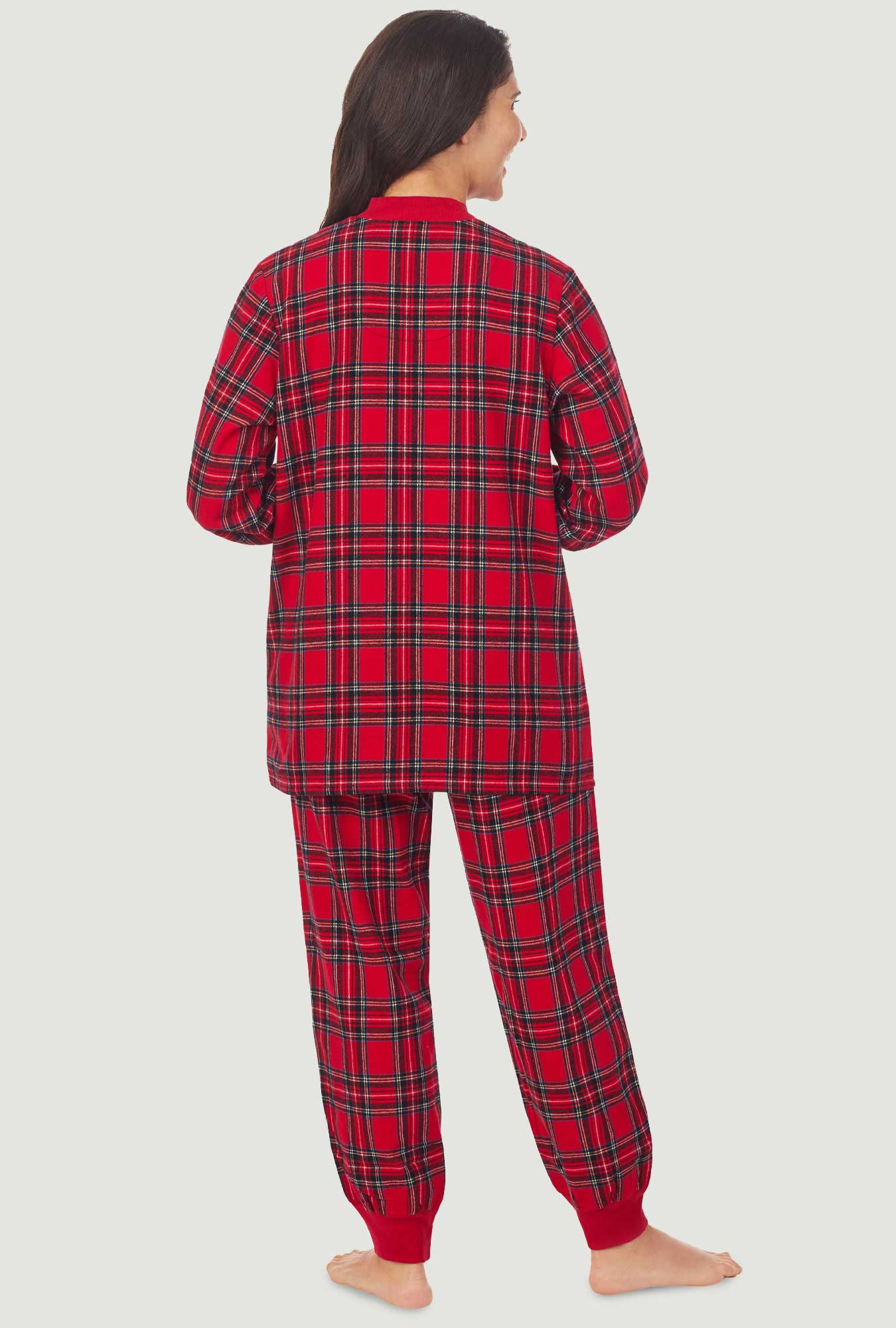 A lady wearing a red tartan long sleeve ski pajama.