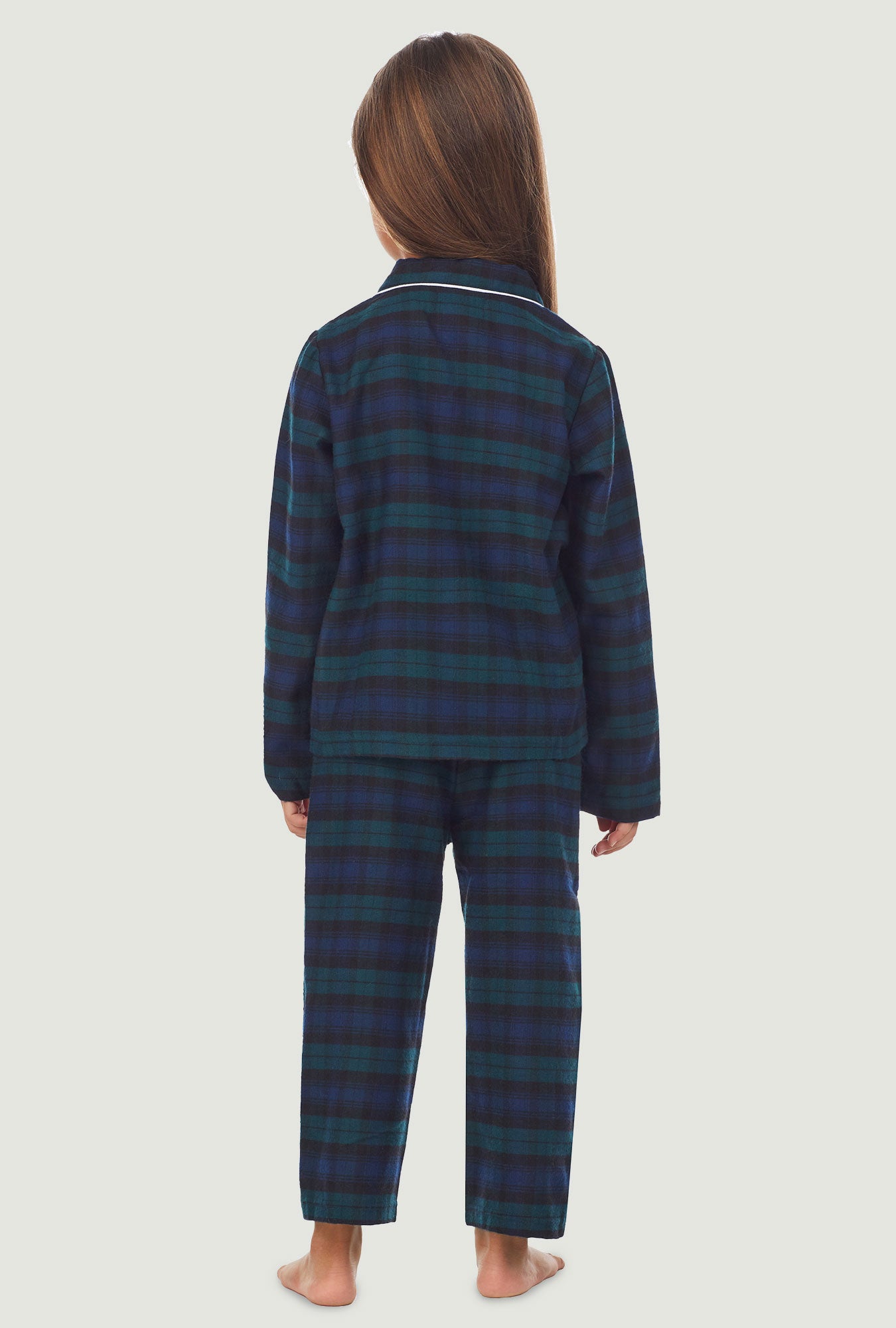A kid wearing a long sleeve pajama set with black watch plaid pattern.