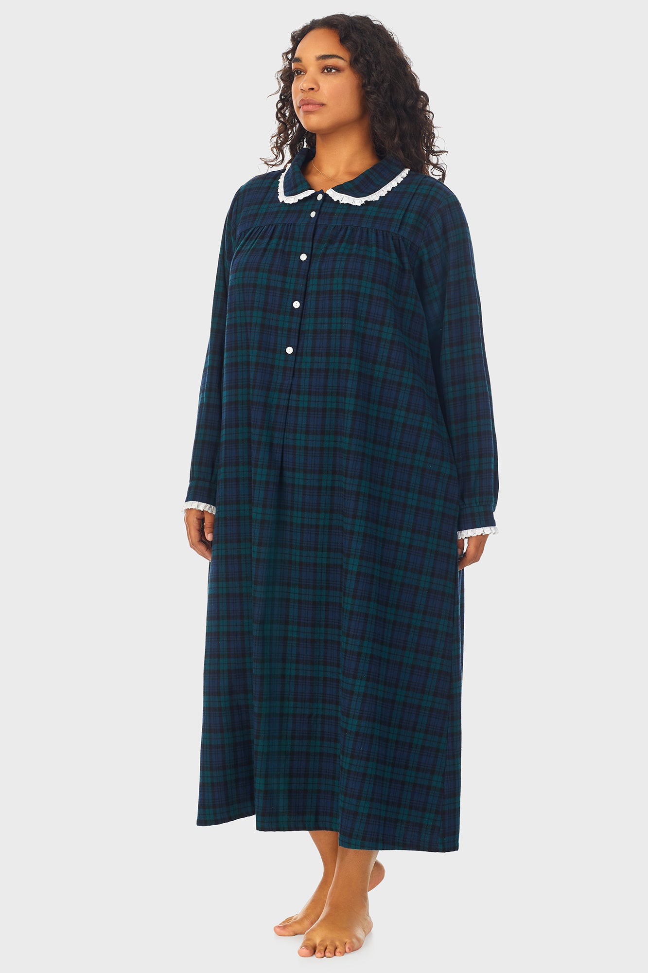 A lady wearing a long sleeve flannel gown plus with black watch peterpan pattern.