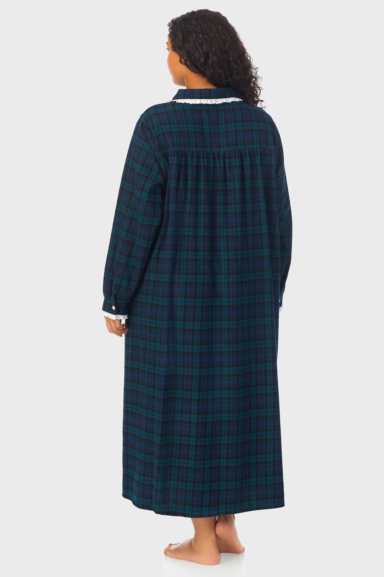 A lady wearing a long sleeve flannel gown plus with black watch peterpan pattern.