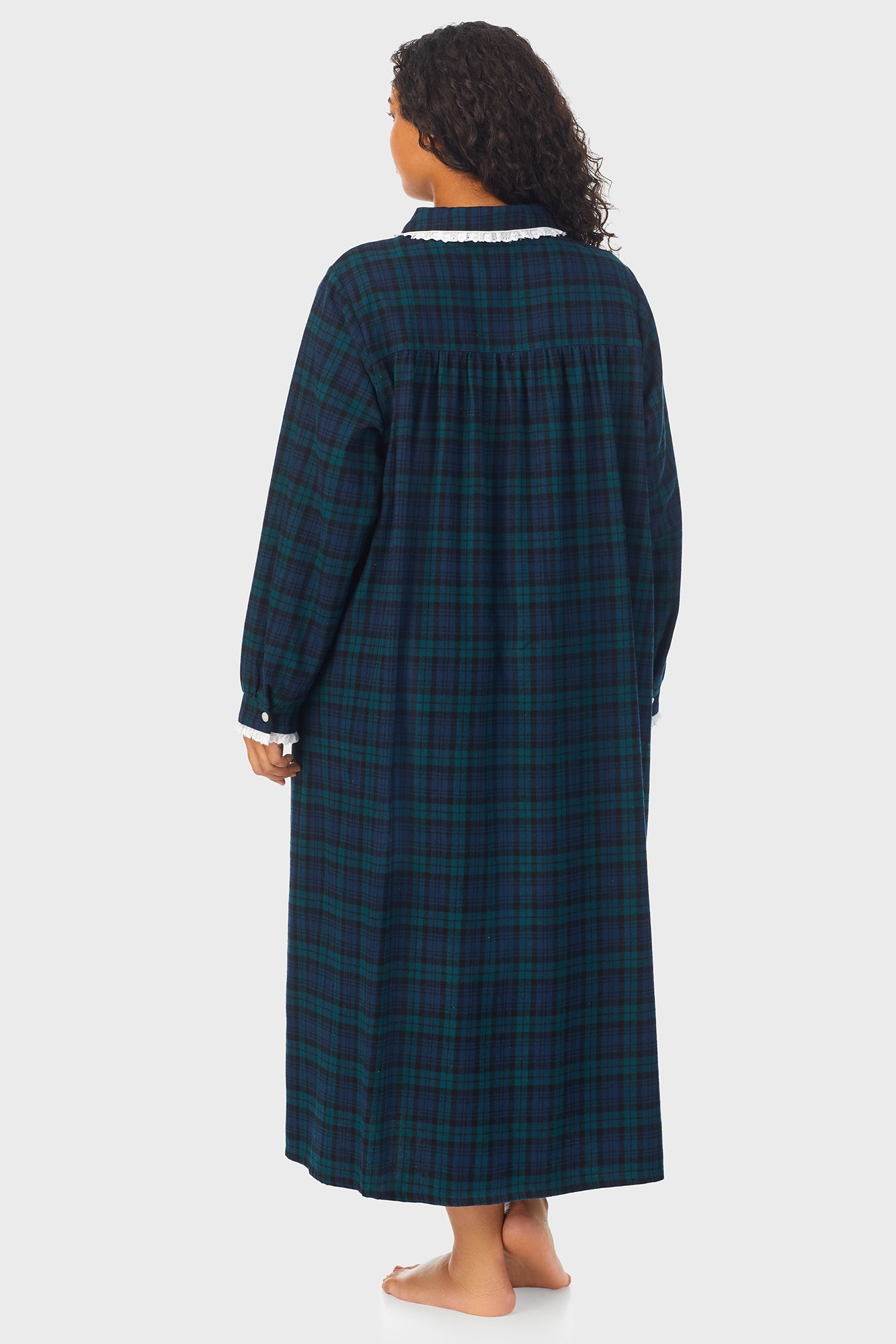  A lady wearing a long sleeve flannel gown plus with black watch peterpan pattern.