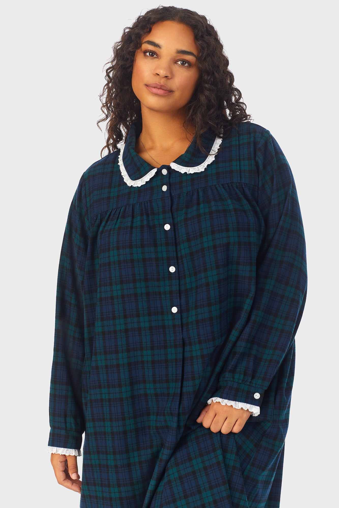 A lady wearing a long sleeve flannel gown plus with black watch peterpan pattern.