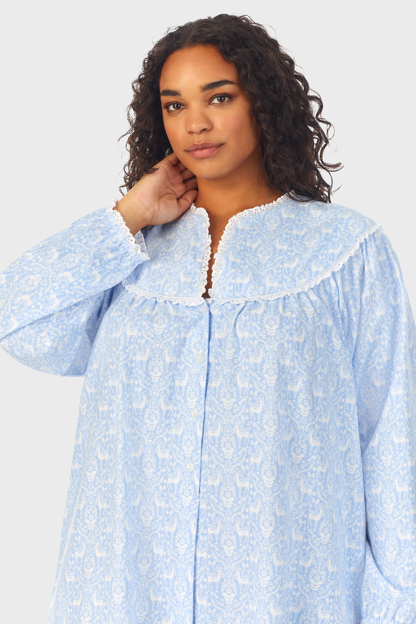 A lady wearing a blue long sleeve flannel gown plus with floral pattern.