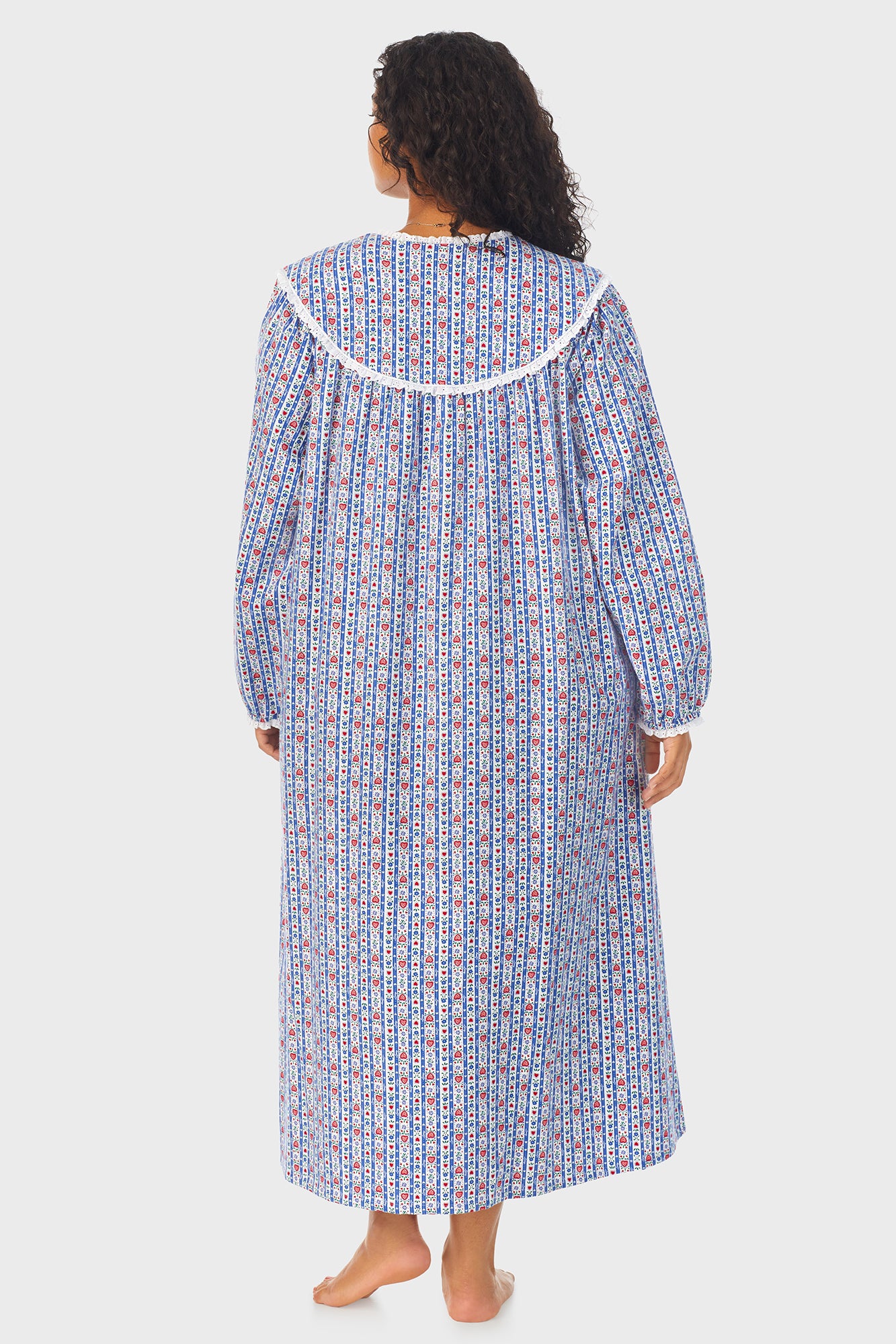 A lady wearing a blue long sleeve flannel nightgown plus with tyrolean stripe pattern.