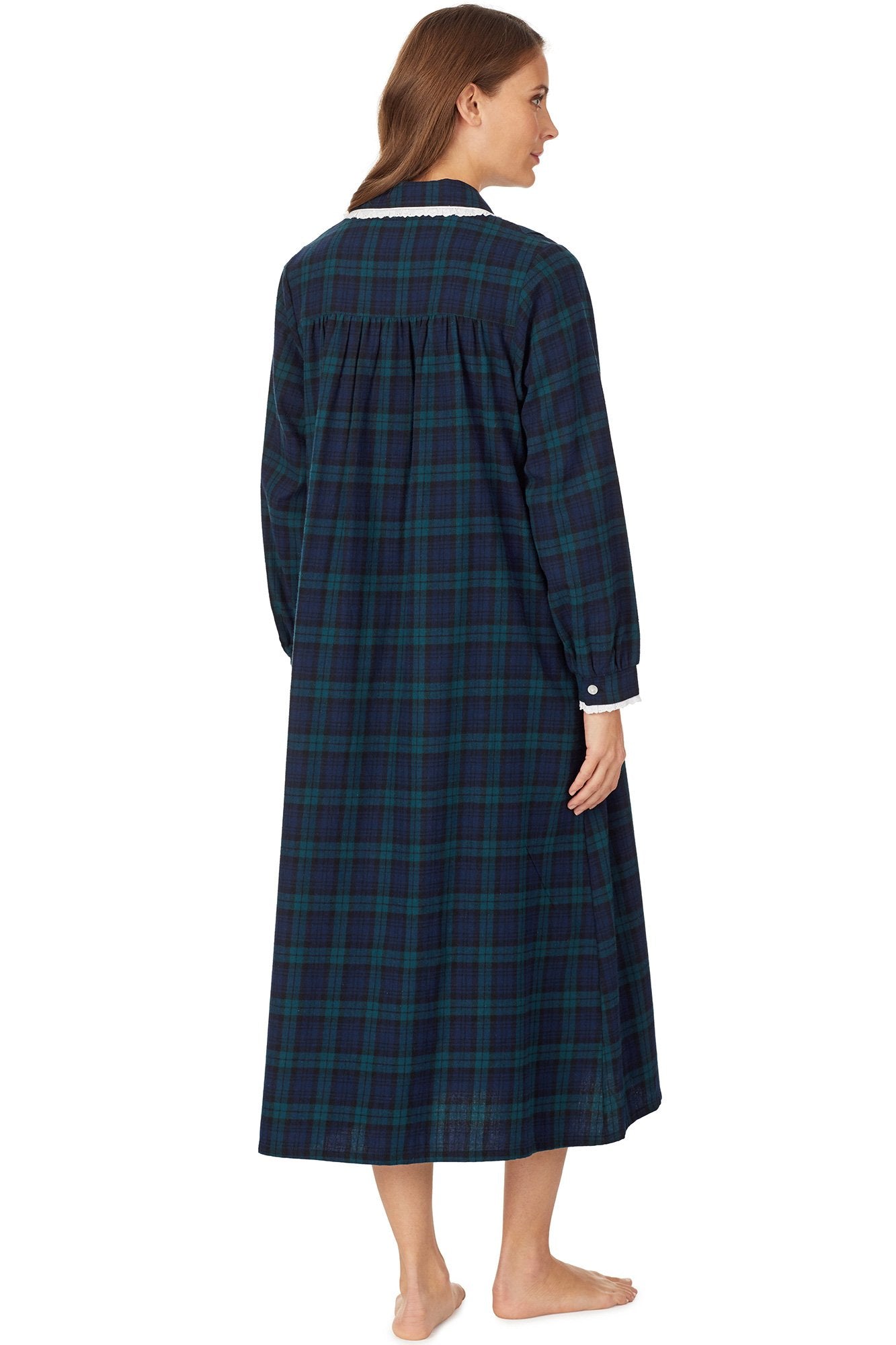 A lady wearing a long sleeve flannel gown petite with black watch plaid pattern.