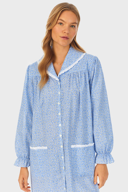 A lady wearing a blue long sleeve short robe with floral pattern.