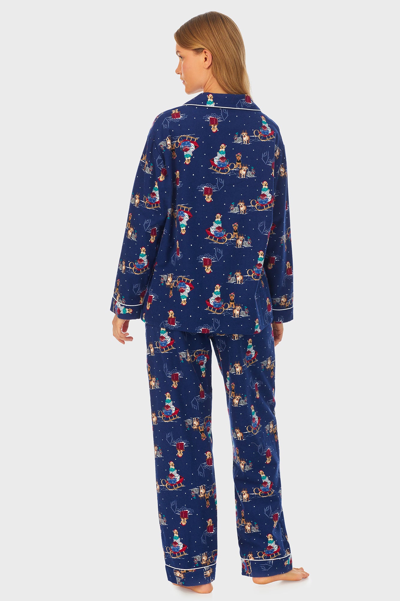 A lady wearing navy long sleeve women's pajama with sleigh puppies print.