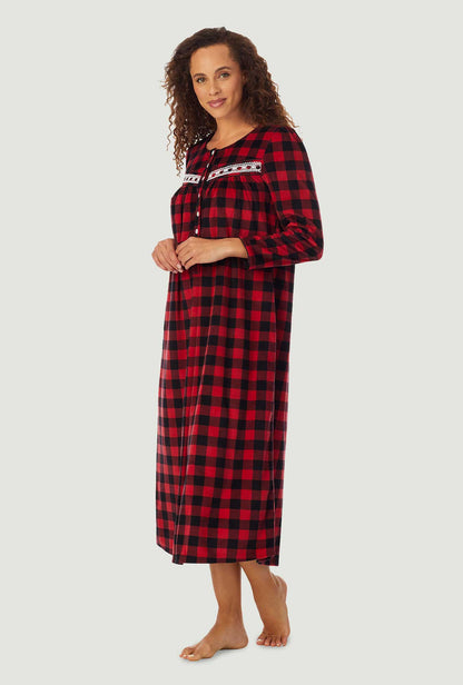 A lady wearing a red check long sleeve cozy fleece gown.