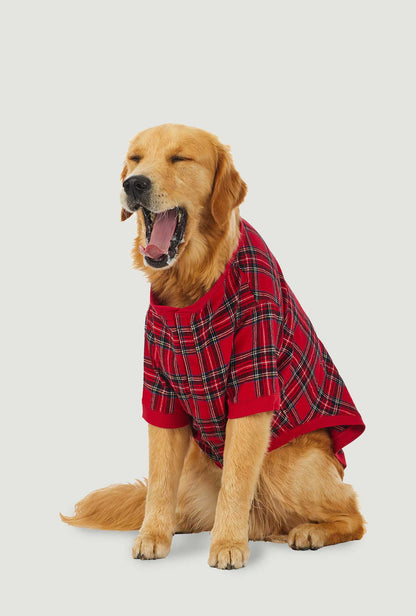 A dog wearing a red plaid short sleeve pajama.