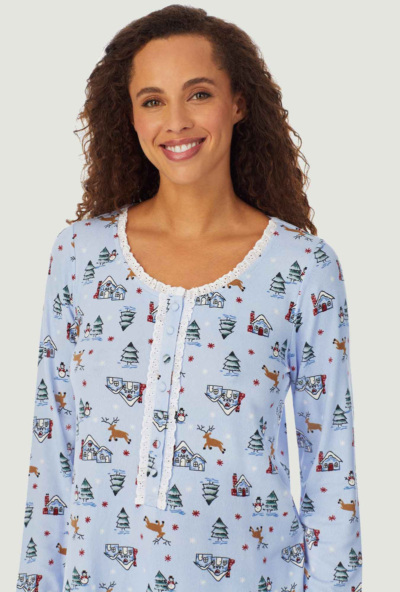 A lady wearing a lanz cozy long sleeve cabin sweater knit henley pajama.