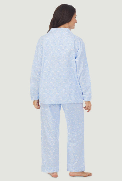 A lady wearing light blue pajama with white pattern