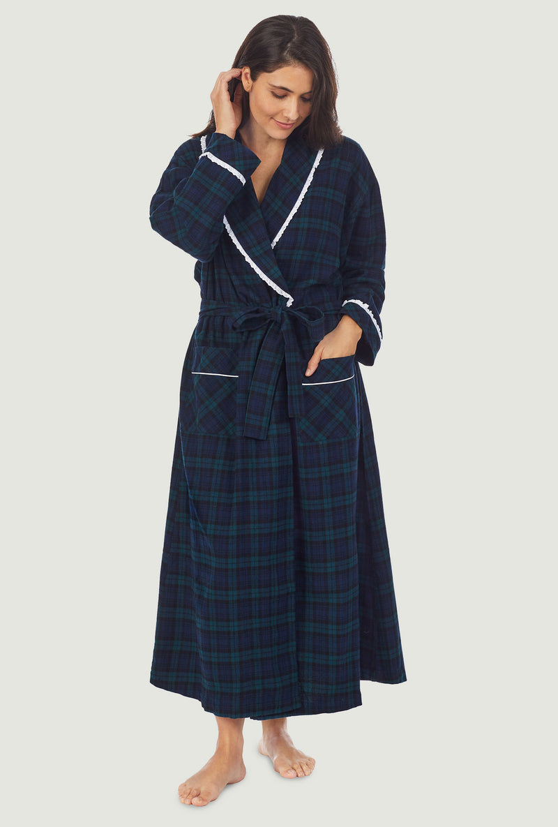 A lady wearing a long sleeve flannel robe with black watch plaid pattern.