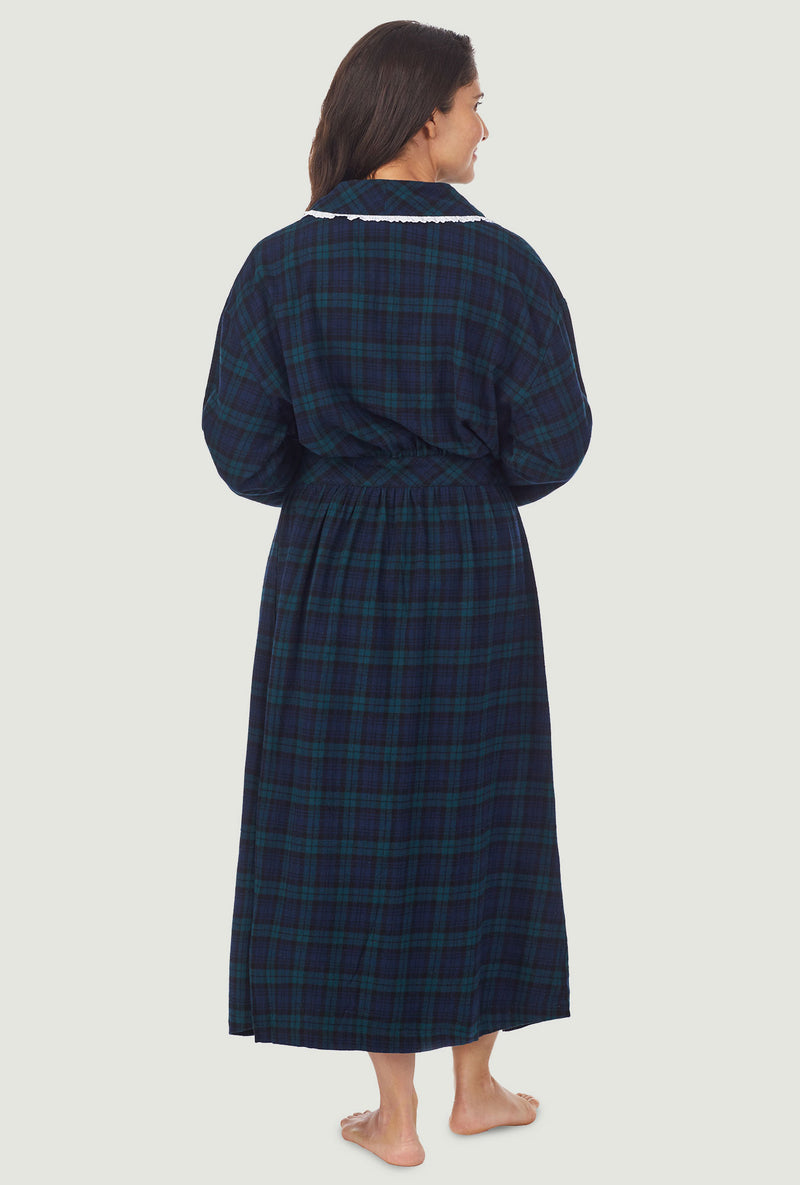 A lady wearing a long sleeve flannel robe with black watch plaid pattern.