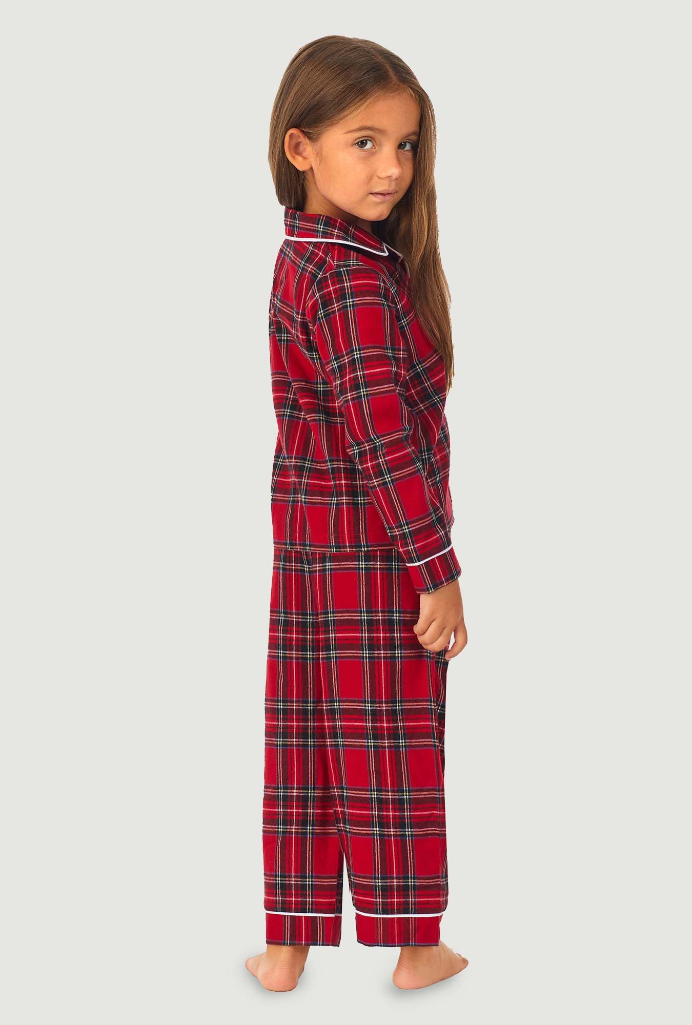 A girl wearing a red tartan long sleeve pajama set.