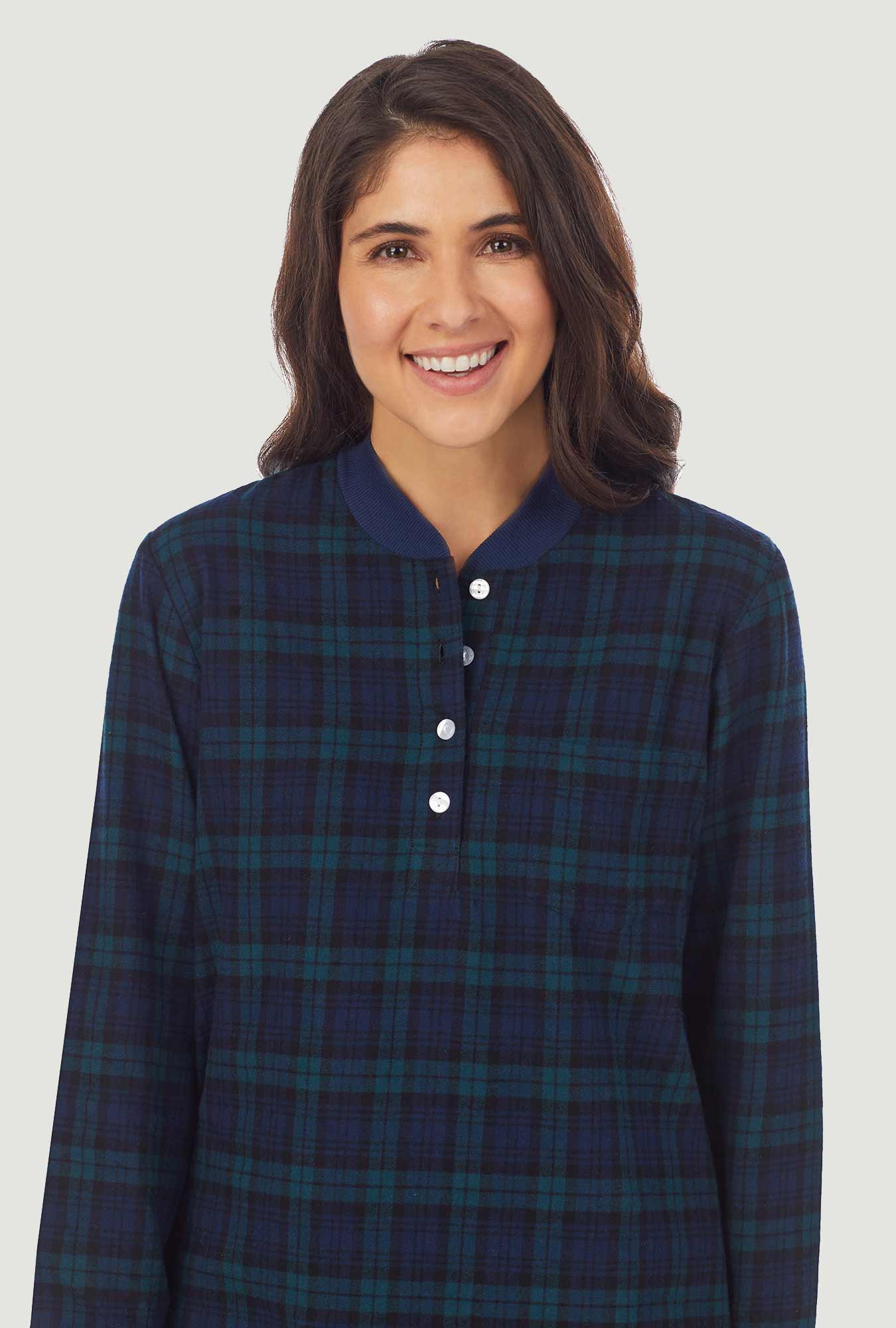 A lady wearing a long sleeve pajama with black watch plaid  pattern.
