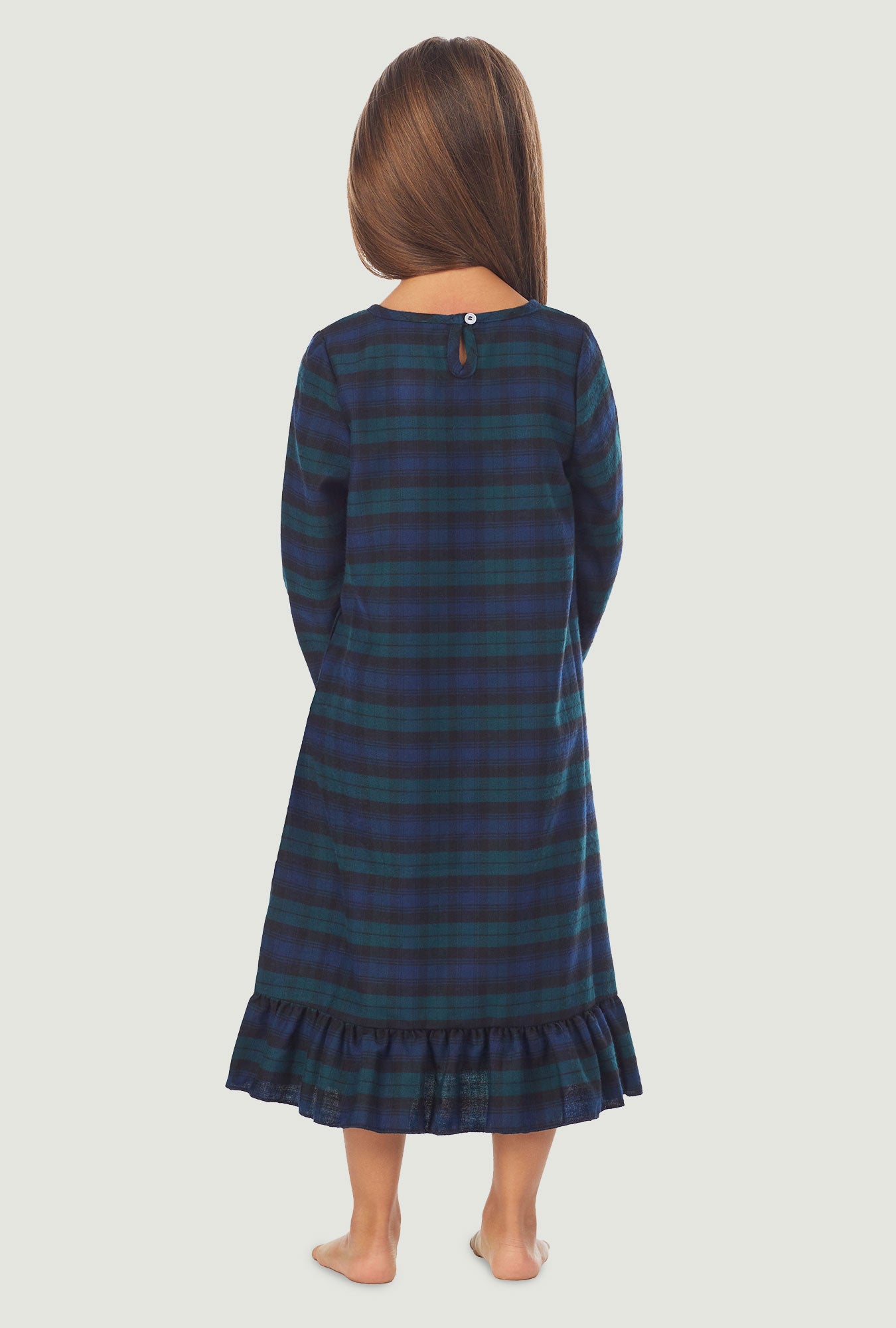 A girl wearing a black watch plaid long sleeve nightgown.