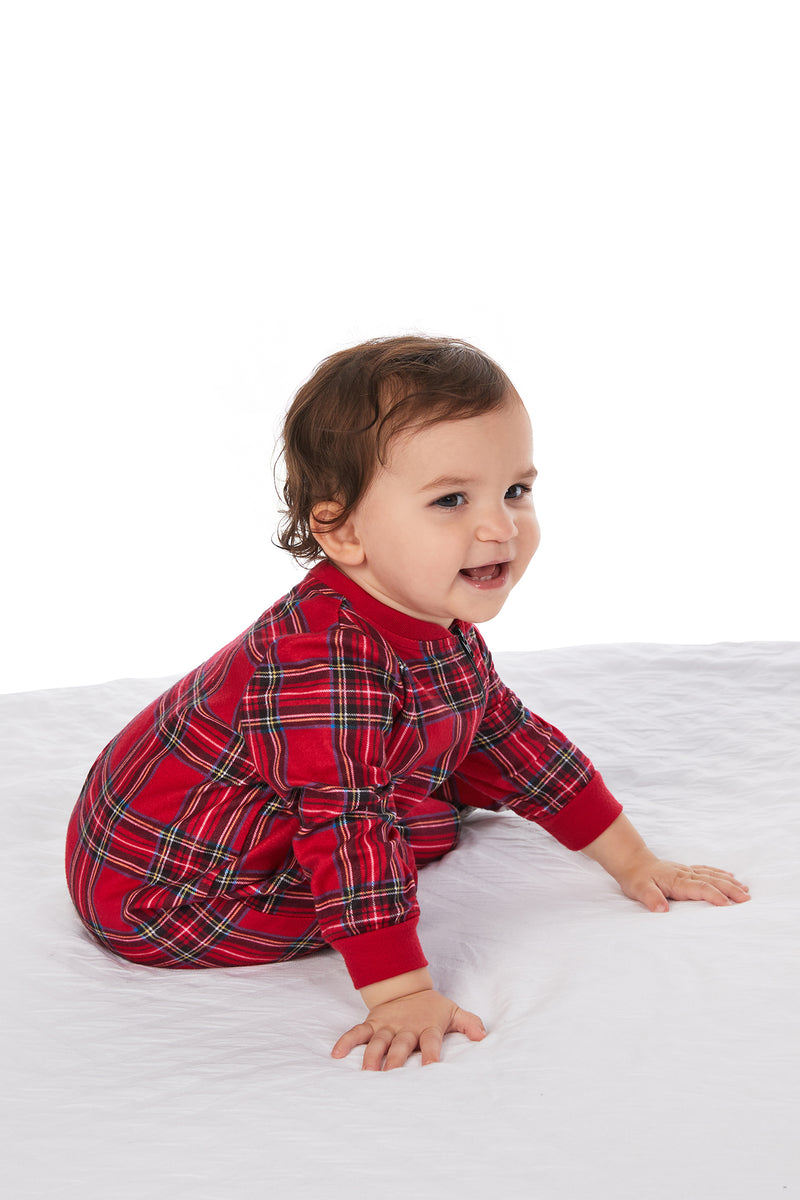 A baby wearing a red tartan long sleeve sleeper.