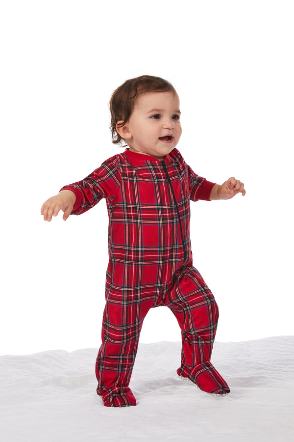 A baby wearing a red tartan long sleeve sleeper.