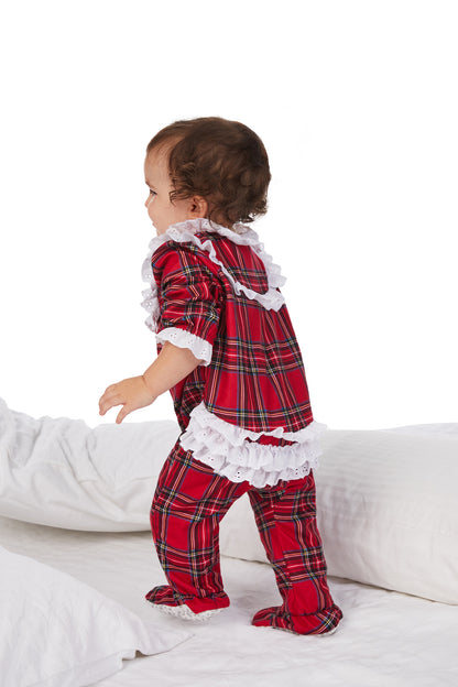 A baby wearing a red tartan long sleeve rumba.