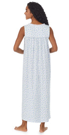 A lady wearing white long nightgown with blue floral design
