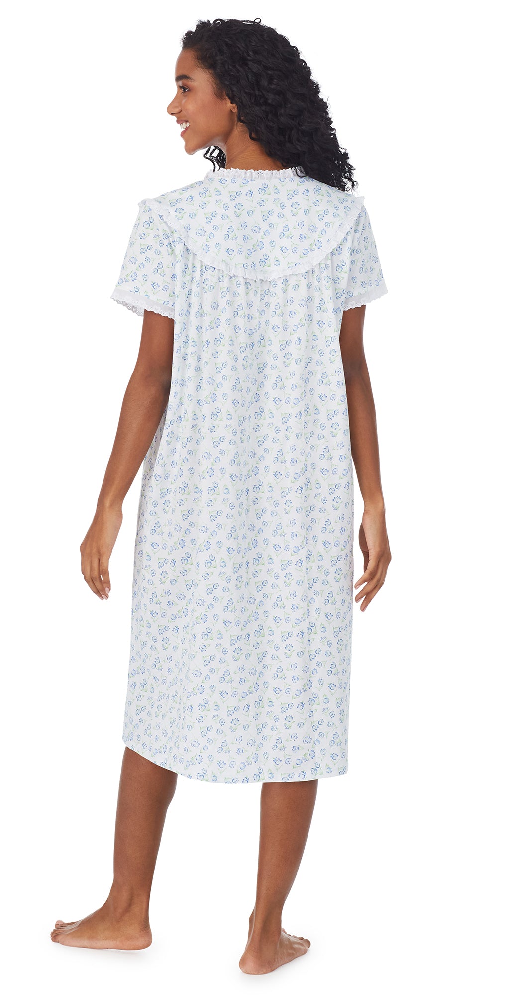 A lady wearing a white short sleeve knit waltz nightgown with tulip pattern.